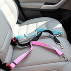 Trois laisses de sécurité pour animaux de compagnie de couleurs différentes (bleu, noir, rose) sont posées sur un siège de voiture en cuir gris, prêtes à l'emploi.