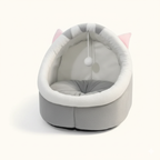 Lit pour chat en forme de dôme gris et blanc avec des rayures et une balle de jeu suspendue, présenté sur un fond uni et clair pour un aperçu propre du produit.